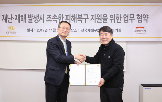 지난달 30일 재난·재해 발생시 성금 모금을 위한 업무협약식에서 신홍섭 KB국민은행 소비자브랜드전략그룹대표(왼쪽)와 전국재해구호협회 박영진 사무총장이 기념촬영을 하고 있다. KB국민은행 제공